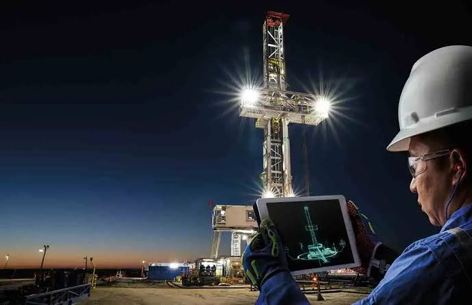 Field engineer reviewing rig schematics at night